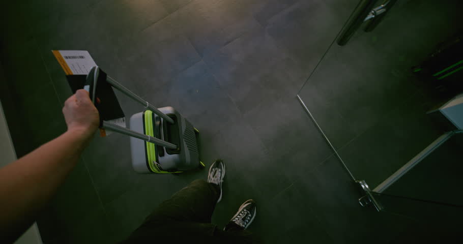 Crowded Airport Terminal: Man Walking with Suitcase, Documents and Plane Ticket After Passport Control. Passenger Sitting in Boarding Lounge of Airline Hub, Waiting for Flight. POV First-Person View.