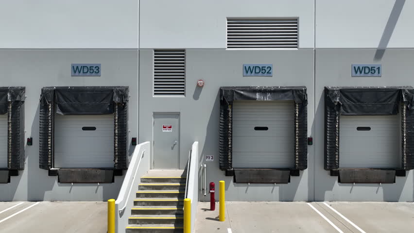 Dolly Right Camera Movement of Empty and Closed Warehouse Shipping Bay Doors.