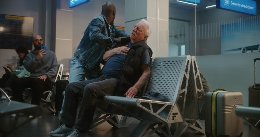Crowded International Airport Terminal: Elderly Man Having Heart Attack, Infarction in Boarding Lounge of Airline Hub. Diverse People Helping Senior Passenger, Airport Worker Calling for Medical Help.