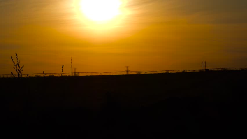 Big bright sun and beautiful sunset over power lines. Mystical mood of the frame, black and red tones and big bright sun.
