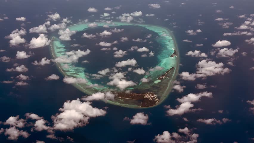 flying along Horsburgh Atoll with Goidhu Island, Fulhadu and Fehendhu. The oval shaped Atoll with lagoon and  island forest at Baa atoll, located at Maldives in Indian Ocean, 4k Aerial video footage
