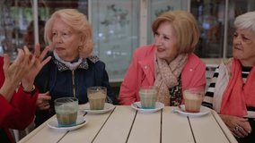Four elegant senior women, dressed in stylish attire, engage in lively conversation while savoring coffee at an outdoor cafe, creating a heartwarming scene of friendship and leisure - Powered by Shutterstock - Get 15% off with code: PIKWIZARD15