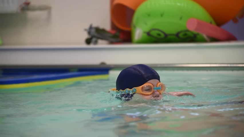 small boy swimming in pool