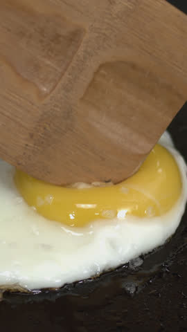 A perfect fried egg sizzling in the skillet, with a golden yolk and crispy edges. A delicious and simple breakfast to start your day, ideal for any time you want a quick, tasty meal. 4K.