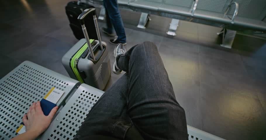Crowded International Airport Terminal: POV First-Person View of Traveler with Suitcase, Passport and Boarding Pass Sitting in Departure Lounge of Airline Hub, Then Walking to Boarding Gate for Flight