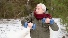 Senior man working out outdoors in winter forest. Person lifting dumbbells. Old male exercising. Healthy people lifestyle. Active sport training. Older elderly sportsman doing fitness. Workout session - Powered by Shutterstock - Get 15% off with code: PIKWIZARD15