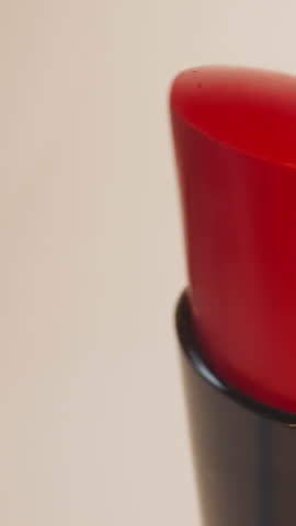 Bright red lipsticks for evening makeup on beige background. Presentation of high-quality cosmetic product for lips in shop for sale extreme closeup