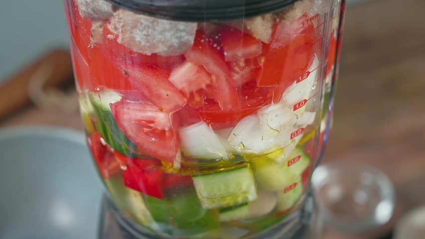 Process of making gazpacho soup. Cook turn on blender and ingredients start to blend