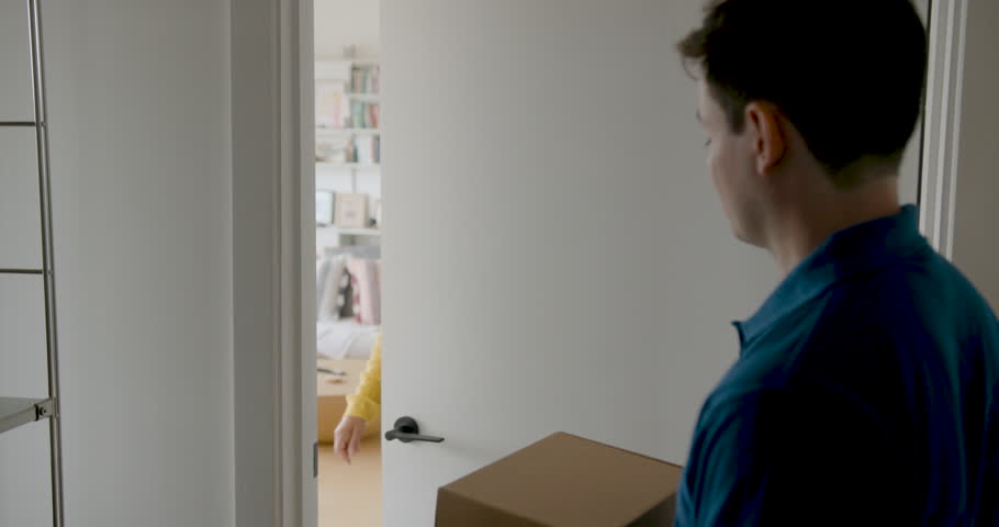 Woman Receiving a Package at Her Doorstep and Signing for Parcel