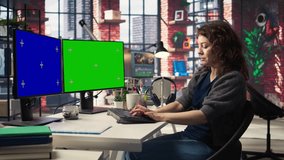 Professional woman works at modern workspace using green screen on dual monitors setup. High tech office environment enhances productivity, IT professionals and content creation. Camera A. - Powered by Shutterstock - Get 15% off with code: PIKWIZARD15