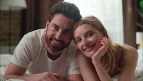 Smiling Caucasian pair couple lying bed together morning carefree wife woman female lady girlfriend looking at camera in bedroom love closeness glad man male husband boyfriend relax family partnership - Powered by Shutterstock - Get 15% off with code: PIKWIZARD15