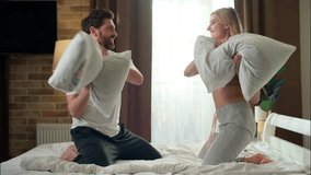 Playful Caucasian married couple fighting pillows happy male laughing boyfriend female playing funny game girlfriend man battle woman fooling around tenderness in bedroom family morning love leisure - Powered by Shutterstock - Get 15% off with code: PIKWIZARD15