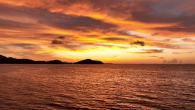 A sunset over the ocean, with vibrant golden and purple tones blending in the sky, and the calm waves reflecting the colors, offering a serene and picturesque view of the coastal landscape. Thailand.
 - Powered by Shutterstock - Get 15% off with code: PIKWIZARD15
