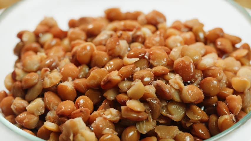 Lentils macro, Open metal can with preserved steamed brown lentils close up isolated on white background 