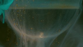 Mist ink. Water cloud sphere. Defocused cyan blue golden color liquid dust paint spreading over transparent bubble on abstract art dark black background. - Powered by Shutterstock - Get 15% off with code: PIKWIZARD15