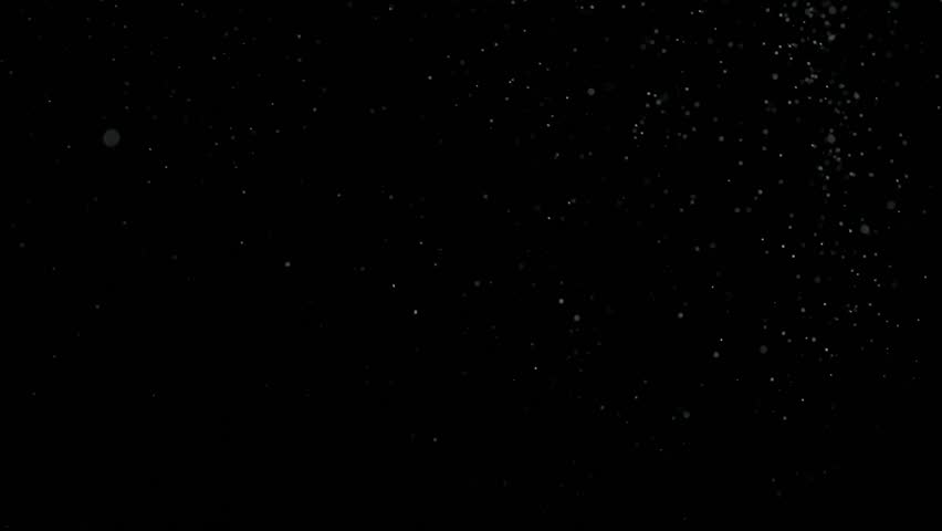Tiny dust randomly flying in the smoky air, empty space template for objects. Many dust particles white powder falling, floating on empty black contrast background. Slow motion.