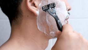 Man shaving with razor and shaving foam side view close-up. - Powered by Shutterstock - Get 15% off with code: PIKWIZARD15
