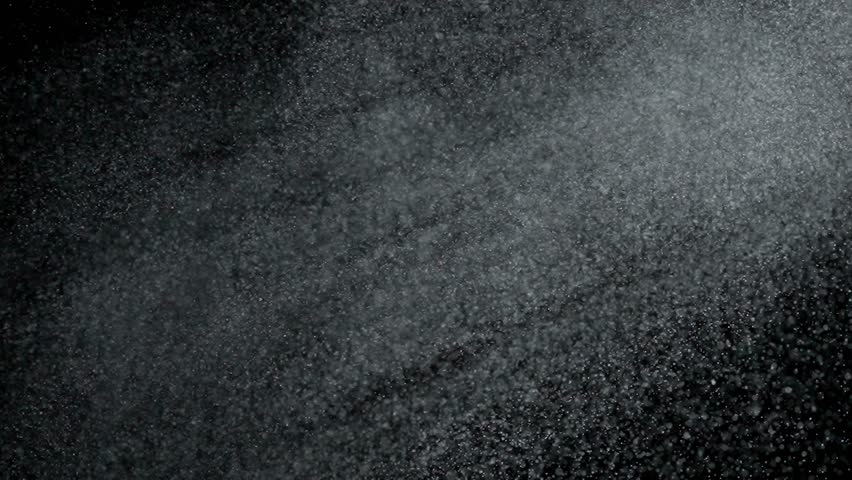 Tiny dust randomly flying in the smoky air, empty space template for objects. Many dust particles white powder blowing floating on empty black contrast background in light rays. Slow motion.