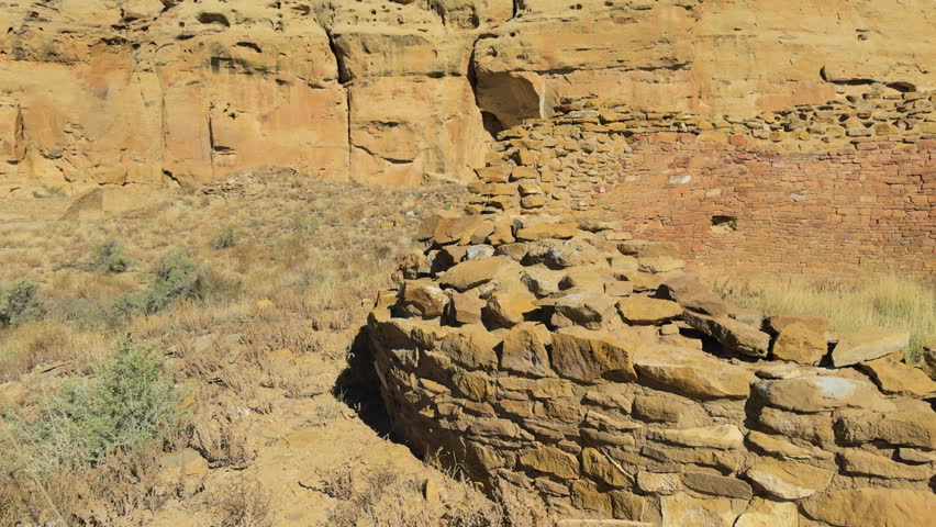 Weathered sandstone wall section from ancestral pueblo ruins under clear desert sky at Chaco Canyon, New Mexico.