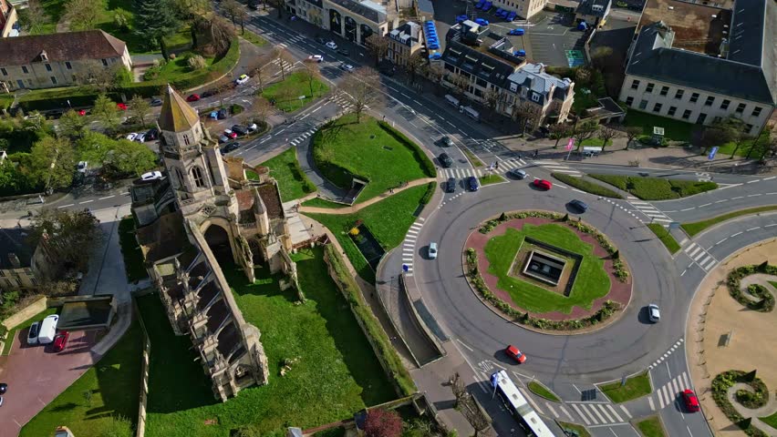 Saint-Étienne-le-Vieux ruins, Old Saint Stephen church, roundabout traffic in Caen, Normandy. Contrasting history and modern life, France. Aerial drone top-down view
