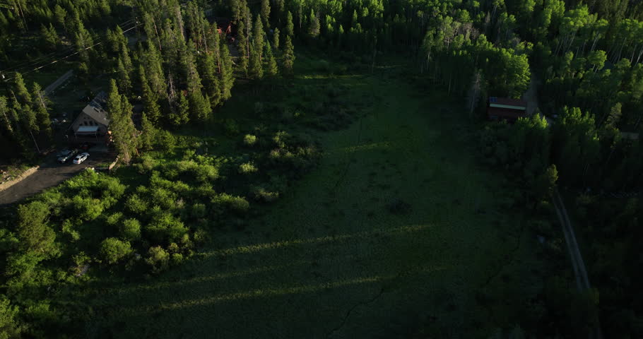 Tilting shot of an open field and mountains at sunrise in Grand Lake Colorado