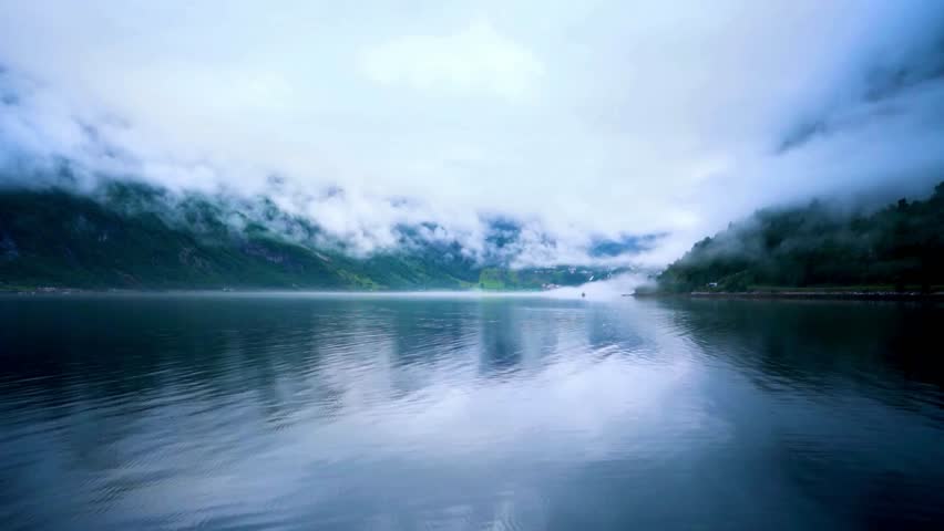 Serene Mountain Lake Landscape with Misty Peaks and Calm Waters