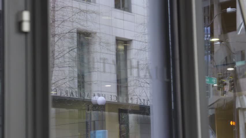 City street view with soft focus shift from police HQ sign to Seattle City Hall sign