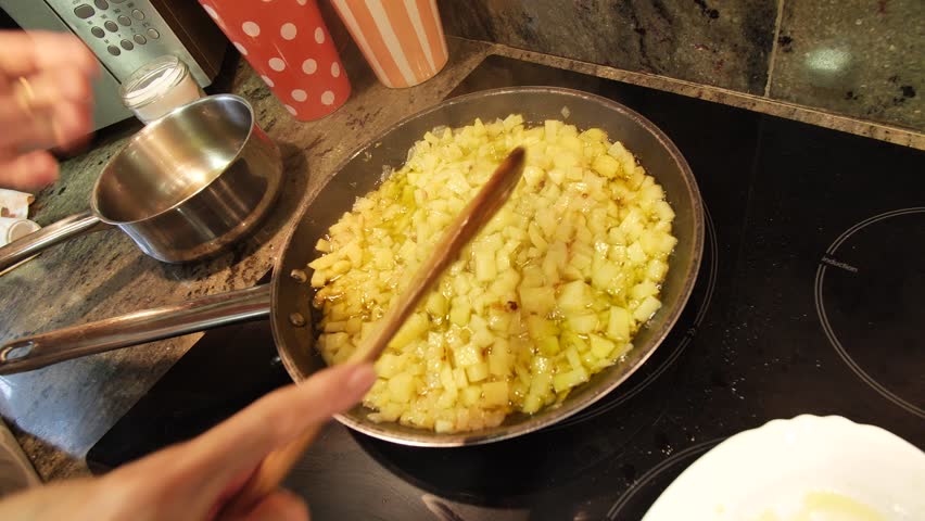 Housewife cooking traditional Spanish omelette at home kitchen. High quality 4k footage.