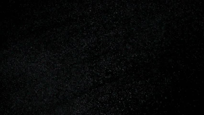 Tiny dust randomly flying in the smoky air, empty space template for objects. Many dust particles white powder floating in darkness on empty black contrast background. Slow motion.