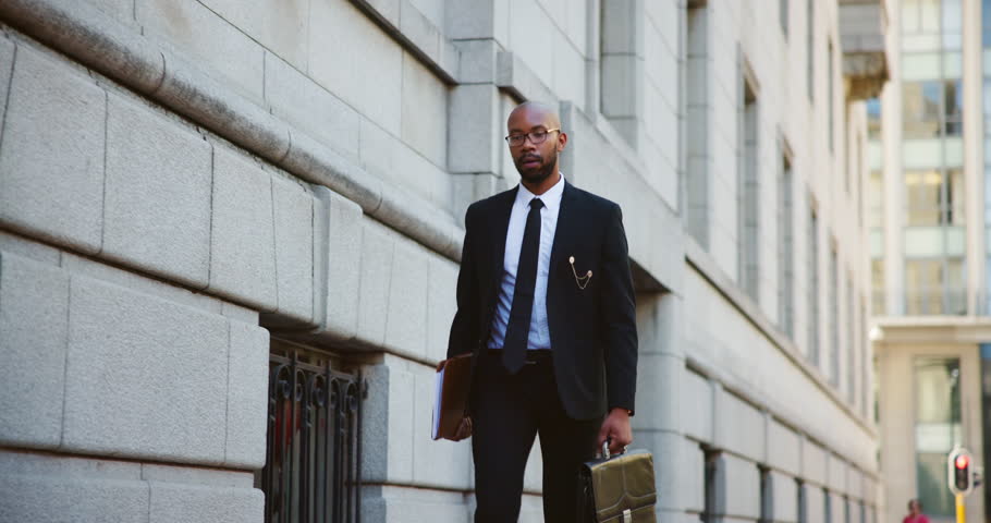 City, folder and walking with black man lawyer outdoor as legal council for court case or trial. Briefcase, buildings and travel with attorney at law downtown for commute to appointment as advocate