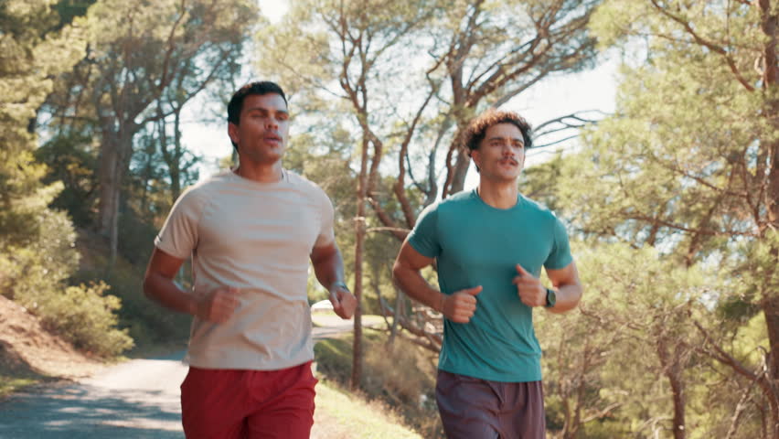 Men, running and fist bump at park, training or path in nature, fitness or support for workout in summer. People, personal trainer and exercise for marathon, outdoor or cardio challenge in Costa Rica