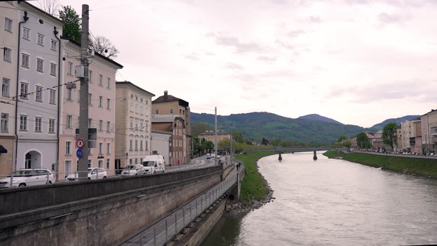 .
Salzburg, Austria. River Salzach in Europe. View the picturesque riverfront in Salzburg featuring beautiful buildings along the banks. Adventure, tourism, travel concept.