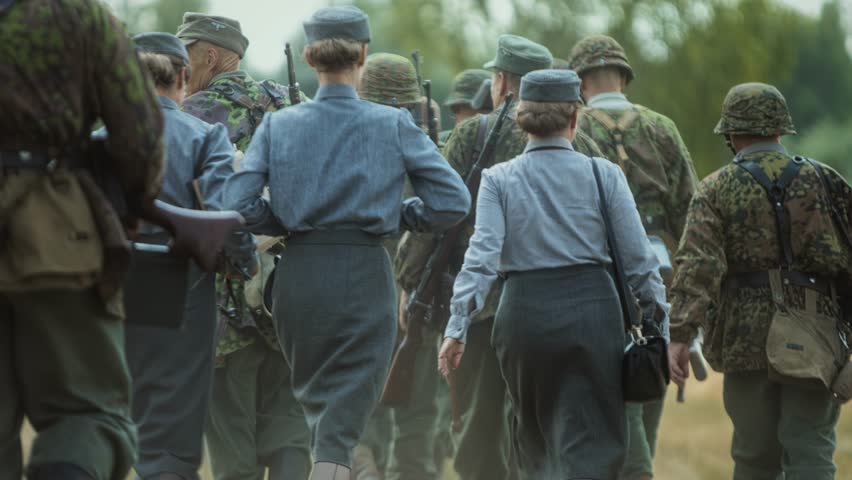 WWII German Waffen-SS soldiers, women auxiliaries Helferinnen Kriegshelferinnen support staff. World War II event. Third Reich army infantry, rear view. Military historical reconstruction in summer