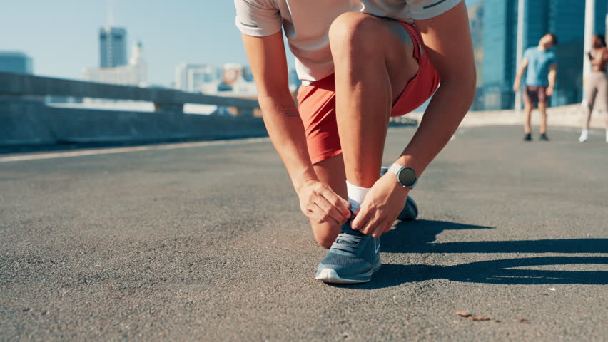 Fitness, man hands and tie shoes in city for running, exercise and workout challenge. Feet, preparation and runner on road for marathon training, start and sneakers for cardio, practice and go