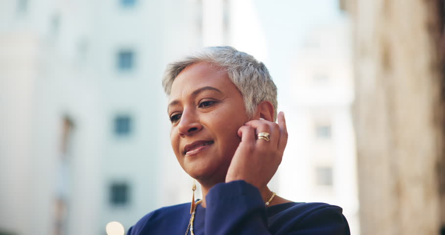 Woman, laugh and dance with earphones in city for listening to music, streaming audio and travel fun. Excited, mature person and moving for groove playlist, morning commute and celebration on journey