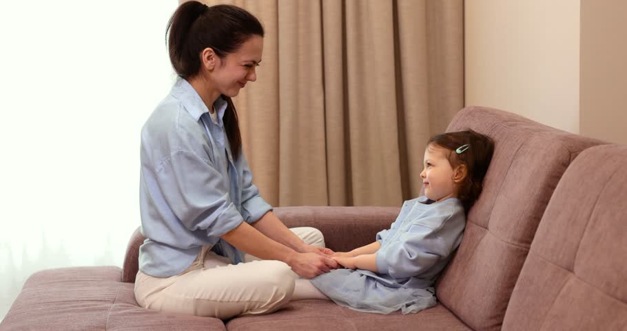 Caring woman talking with her little child girl , supporting at home. Childhood