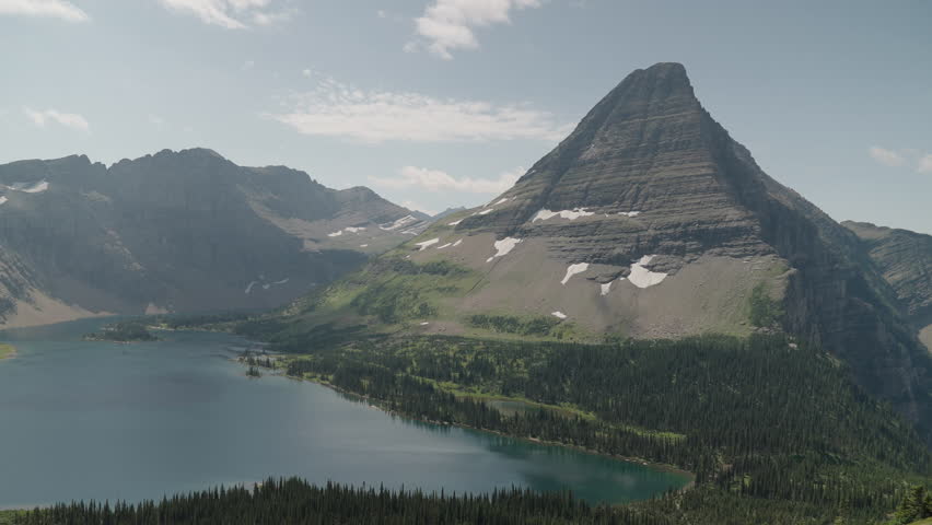 A serene lake surrounded by rugged mountain peaks in logan pass, montana, aerial view