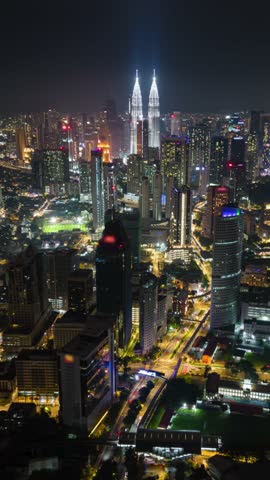 Aerial timelapse of Kuala Lumpur skyline at night with glowing skyscrapers, city lights, and traffic in motion. Ideal for urban, travel, and architecture themes.