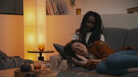 Tender evening with a multiracial lesbian couple -relaxed on the couch, sharing soft touches and quiet affection as they rest together in a warm, intimate home setting. - Powered by Shutterstock - Get 15% off with code: PIKWIZARD15