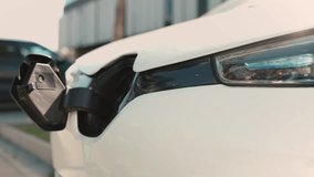 Caucasian male plugging charging cable into electric vehicle while glowing holographic diagrams floating nearby. Digital interface displaying battery level. Power flow, and smart energy management. - Powered by Shutterstock - Get 15% off with code: PIKWIZARD15