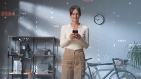Attractive young woman standing in modern office, holding smartphone and browsing digital content. Floating futuristic data visualizations surrounding her. Displaying statistics and analytics. - Powered by Shutterstock - Get 15% off with code: PIKWIZARD15