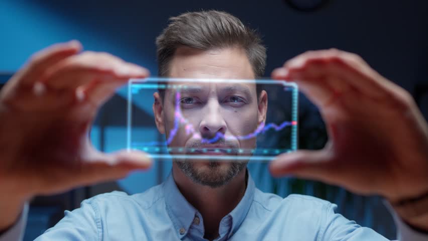 Serious Caucasian man holding futuristic transparent screen while analyzing stock market trends. Digital financial chart glowing on interface. Actively changing prices. Advanced investment concept. - Powered by Shutterstock - Get 15% off with code: PIKWIZARD15