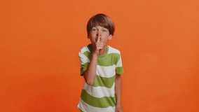 Shh be quiet please. Young preteen child boy kid presses index finger to lips makes silence gesture sign do not tells secret, stop talk gossip, confidential privacy isolated on orange background - Powered by Shutterstock - Get 15% off with code: PIKWIZARD15