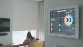 A modern smart home control panel shows room temperature and various settings in a stylish interior. This image captures the essence of smart technology in everyday living spaces. - Powered by Shutterstock - Get 15% off with code: PIKWIZARD15