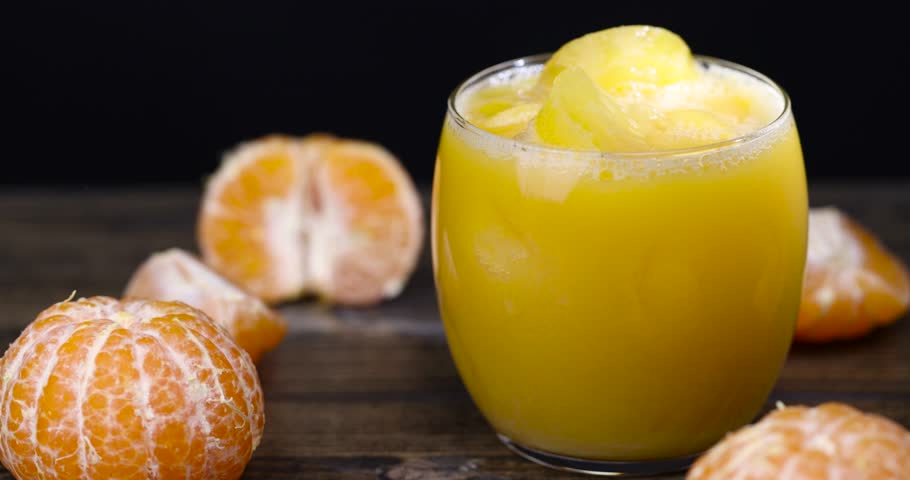 orange mandarin juice in a glass glass, cold orange juice in a glass with ice