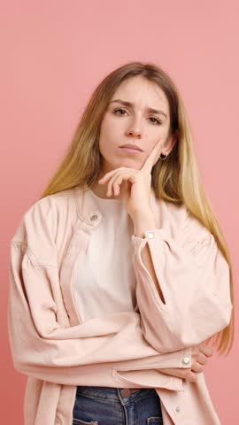 Studio portrait of a young woman expressing various emotions and gestures against a vibrant pink backdrop