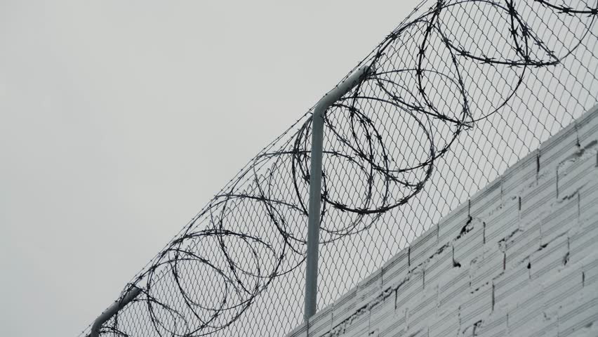 Security systems restricted area. Sharp razor blades on barbed wire. Prison wall. High quality 4k footage