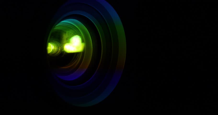 Spectral decomposition of light. Dispersion - decomposition of light into spectral colors. Projector lens in operation. Black background