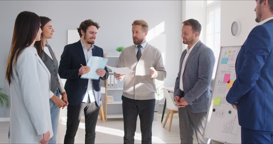 Team of business people applauding and shaking hands with their manager at work meeting showing recognition for his expertise that helped find good solution and develop successful leadership strategy