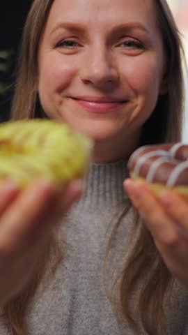 Woman with eating disorder eating two donuts with pleasure and at the same time
